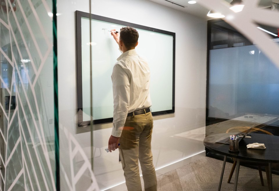 Salesforce consultant planning a CRM solution at a glass whiteboard in a modern office
