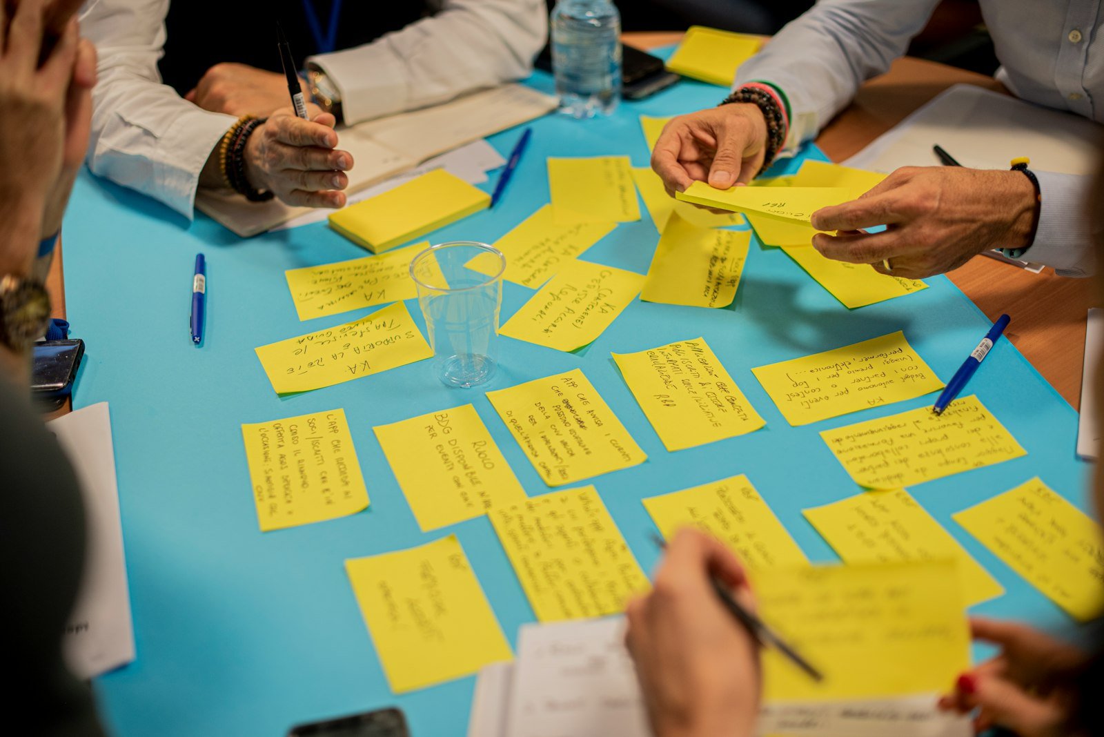 Team members adding ideas to sticky-note boards during a planning workshop