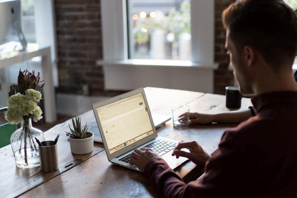 Professional reviewing a business system on a laptop in a bright office