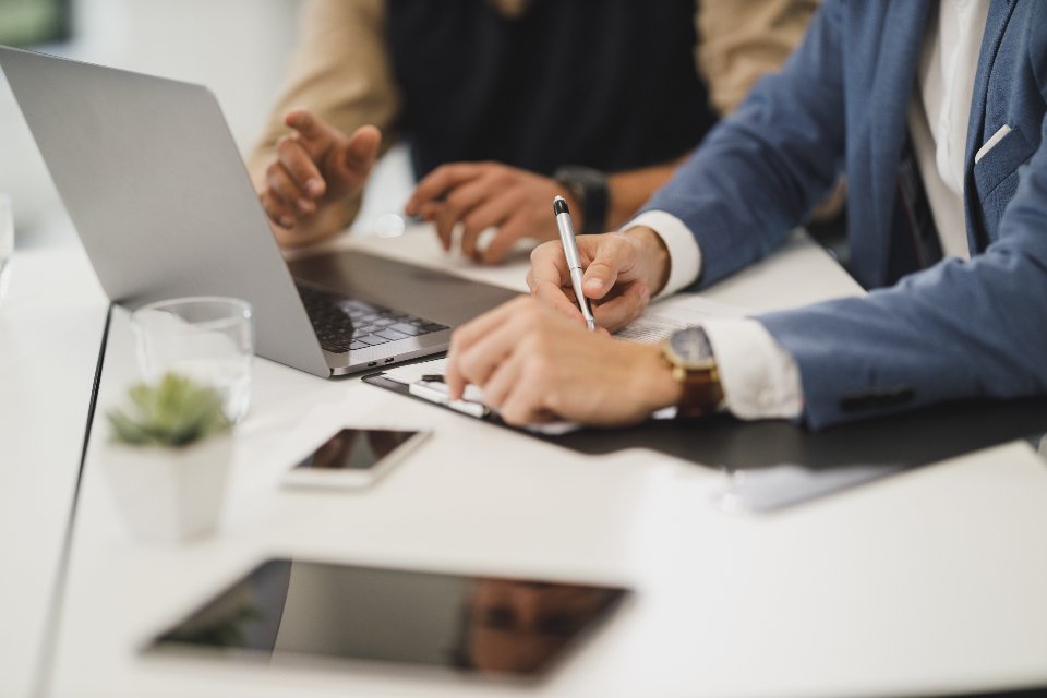 Business advisors reviewing CRM plans with a client at a meeting table